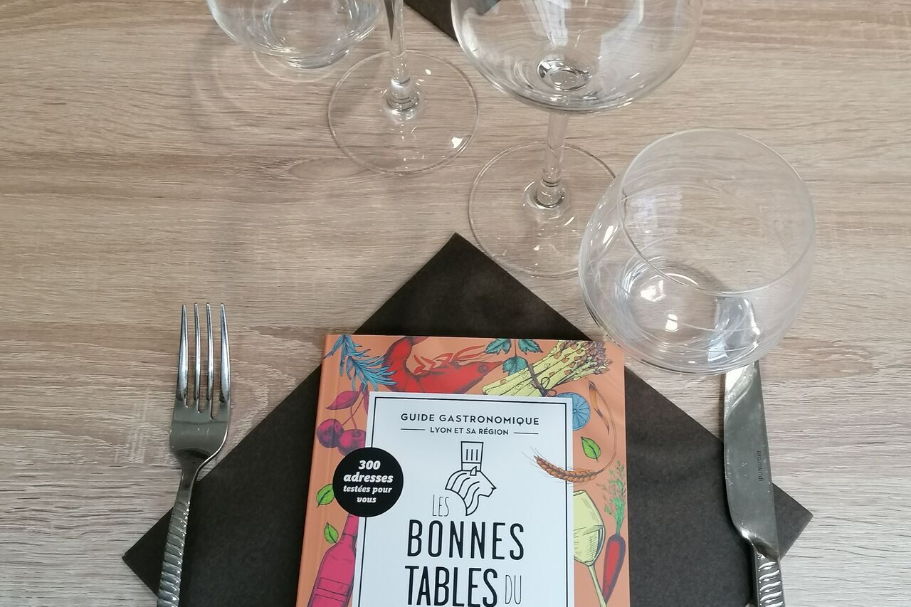 Guide des bonnes tables du Progrès posé sur une table du restaurant